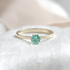 Gold engagement ring with emerald JADE in a centered front view