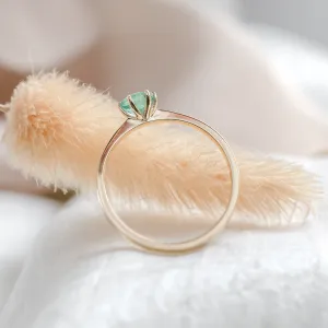 JADE gold engagement ring with emerald, angled detail of the setting and band