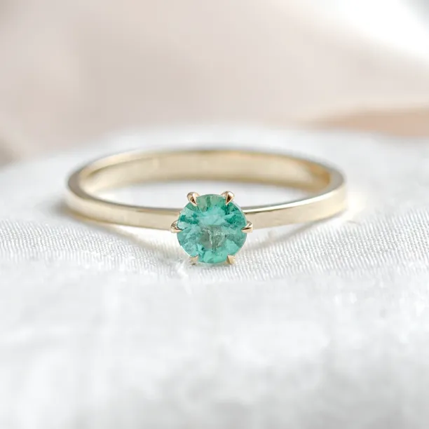 Gold engagement ring with emerald JADE in a clear front-facing view