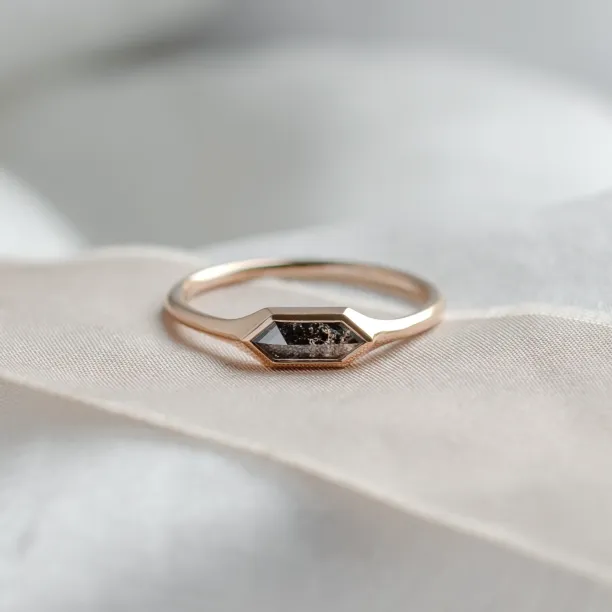 Close-up of gold engagement ring with a hexagon salt and pepper diamond