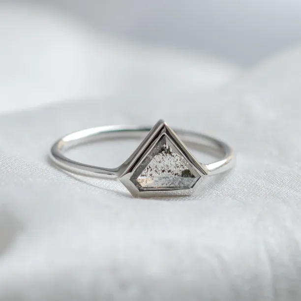 Angled close-up of the HERO gold ring with a superman salt and pepper diamond