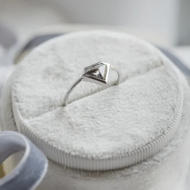 Angled view of the HERO gold ring with its salt and pepper diamond