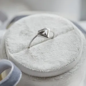 Angled view of the HERO gold ring with its salt and pepper diamond