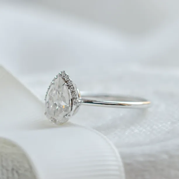 Angled side view of the KIMBER engagement ring setting and pear moissanite