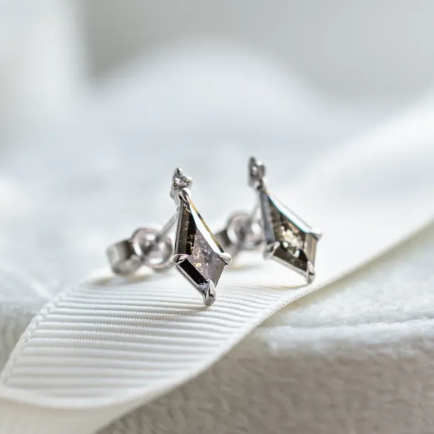 Angled pair of gold POE earrings with kite salt and pepper diamonds