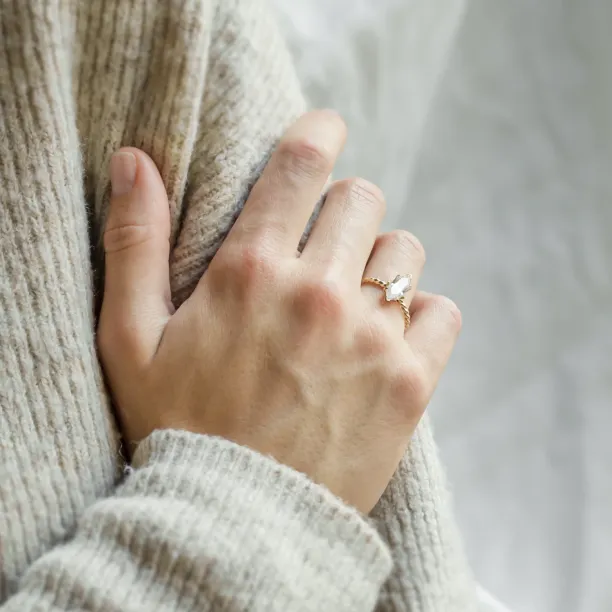 Gold SALEM ring with hexagon moissanite worn on a hand, close-up