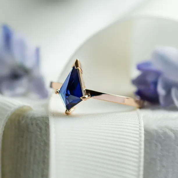 Angled close-up of the KODA gold ring with a blue lab-grown sapphire