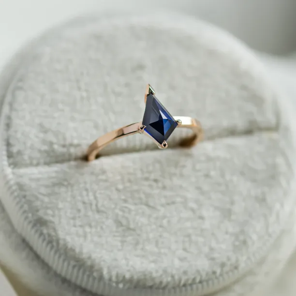 Angled view of the KODA gold ring and its blue lab-grown sapphire