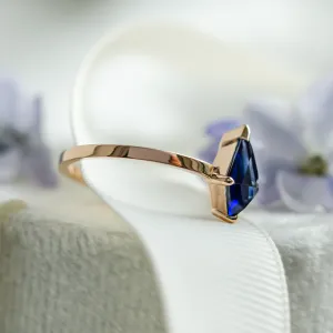 Side view of the KODA gold ring with its kite-shaped blue sapphire
