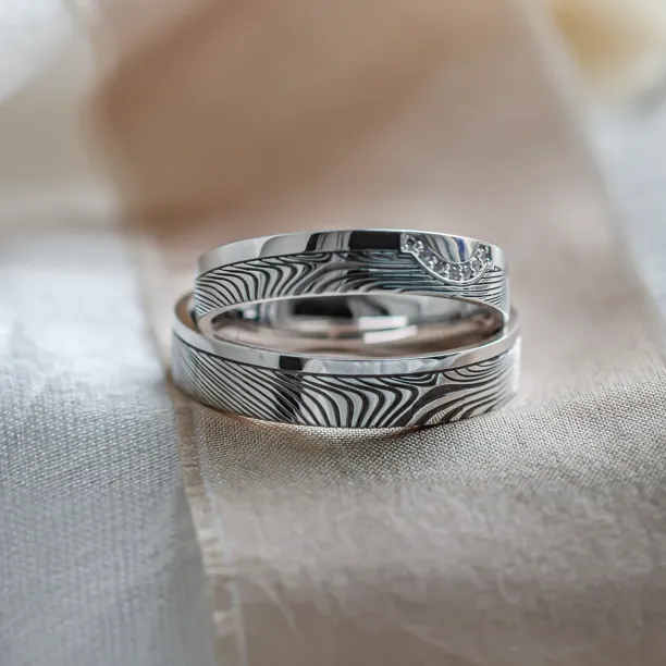 Wedding rings with abstract relief and diamonds OMEGA Image