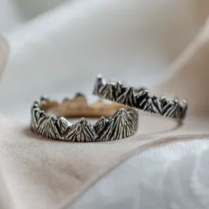 Angled view of SILVRETTA wedding rings with mountain relief and black rhodium