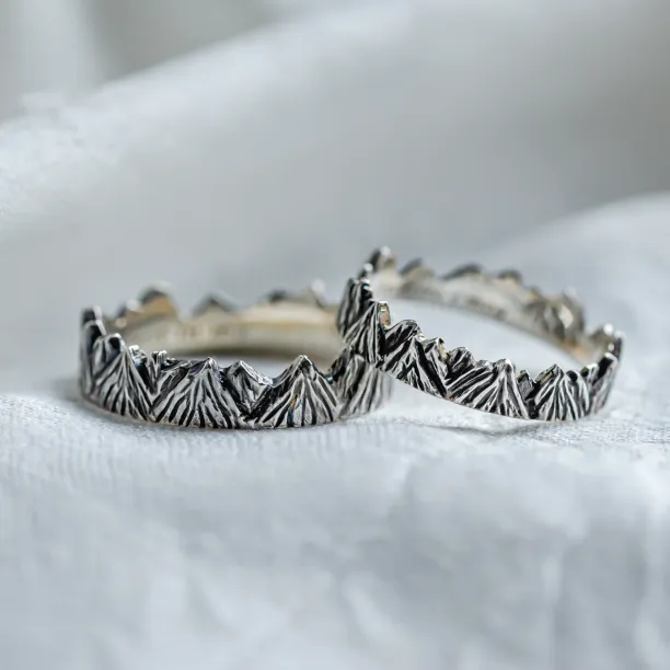 Close angled view of SILVRETTA mountain-shaped wedding rings with black rhodium