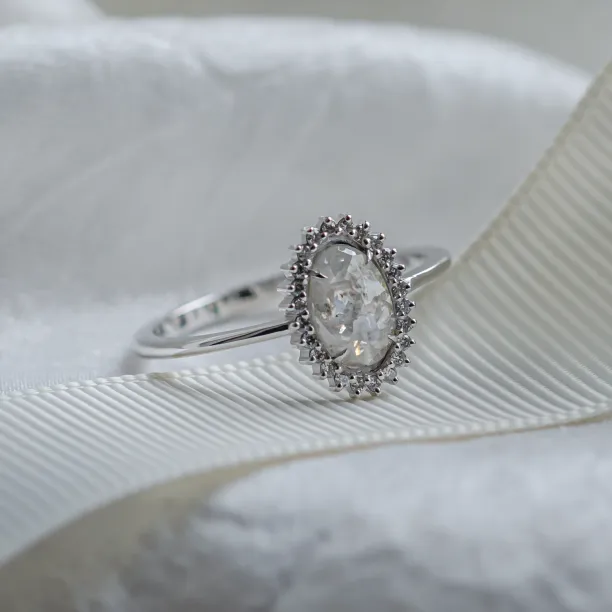 Angled close-up of the RIDLEY halo ring with salt and pepper diamonds