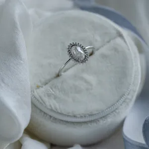 Angled view of the RIDLEY gold halo engagement ring with an oval salt and pepper diamond
