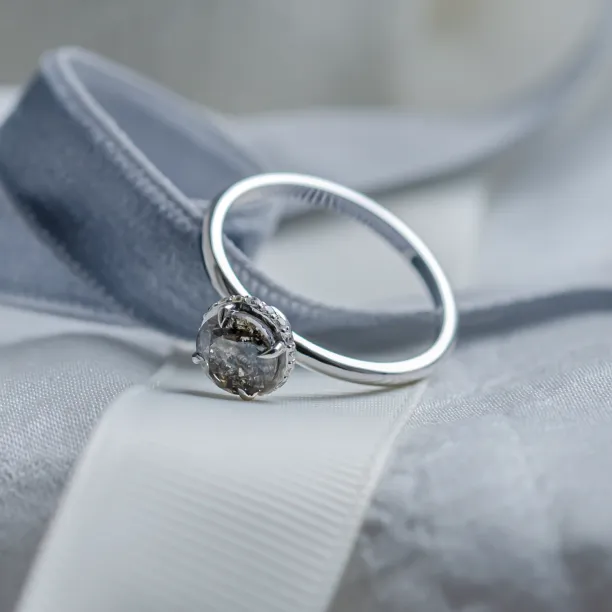 Angled view of the TANAQUIL gold engagement ring with a salt and pepper diamond