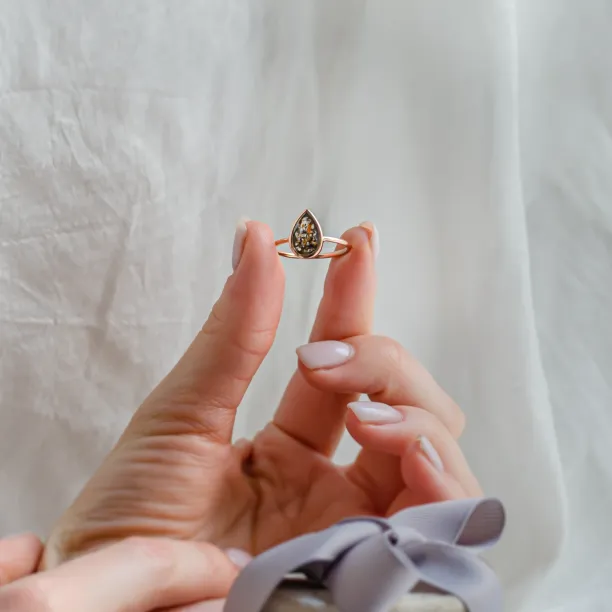 FLAVIA ring with a salt and pepper diamond held between fingers