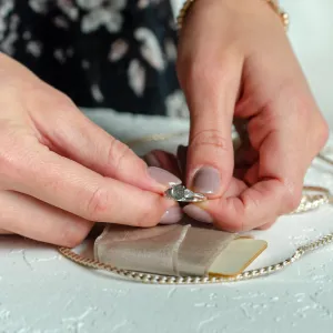 Zásnubní prsten AURELIO se salt'n'pepper diamanty držený mezi dvěma rukama
