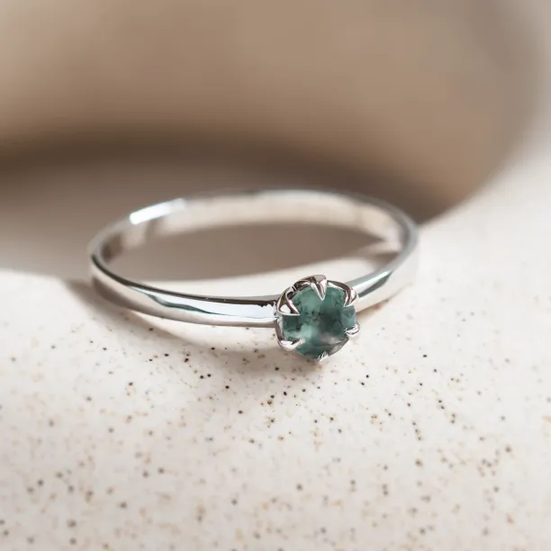 Angled close-up of the minimalist moss agate ring