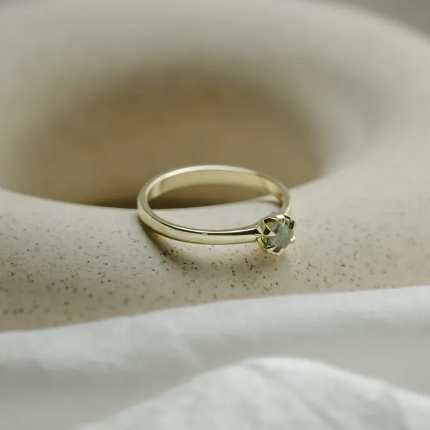 Angled close-up of the minimalist moss agate ring