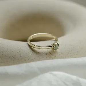 Angled close-up of the minimalist moss agate ring