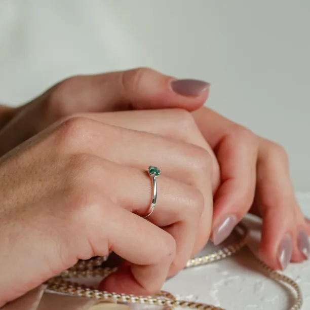 Minimalist moss agate ring worn on a hand, angled view