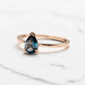 Angled view of a gold ring with London blue topaz