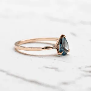 Side view of a gold ring with London blue topaz