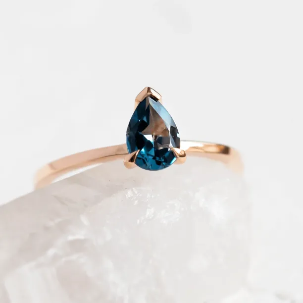 Close-up of a rose gold ring with London blue topaz
