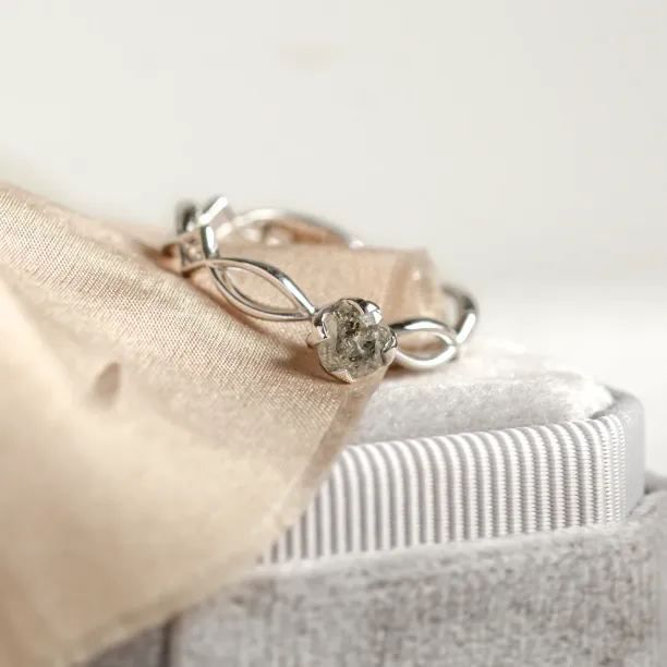 Šikmý pohled na propletený prsten a jeho salt and pepper diamant