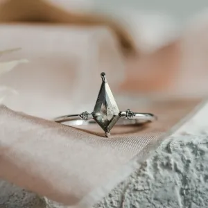 Close-up of the VALENTINO gold engagement ring with a kite-shaped salt'n'pepper diamond