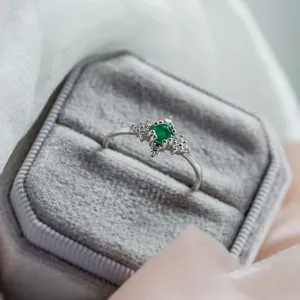 Gold emerald ring with diamonds shown from an angled view