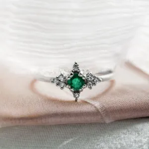 Front close-up of a gold emerald ring with diamonds