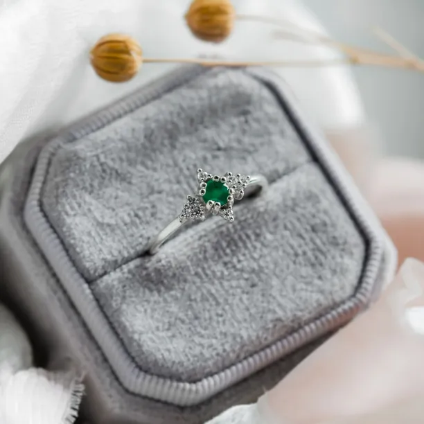 Angled close-up of the ELA gold emerald ring with diamonds