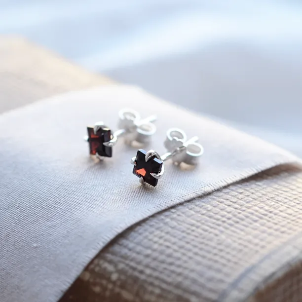 Close-up angled view of GARNI gold garnet earrings