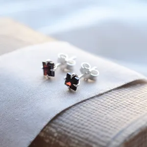 Close-up angled view of GARNI gold garnet earrings