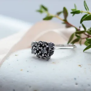 Angled view of a gold cluster ring with salt and pepper diamonds