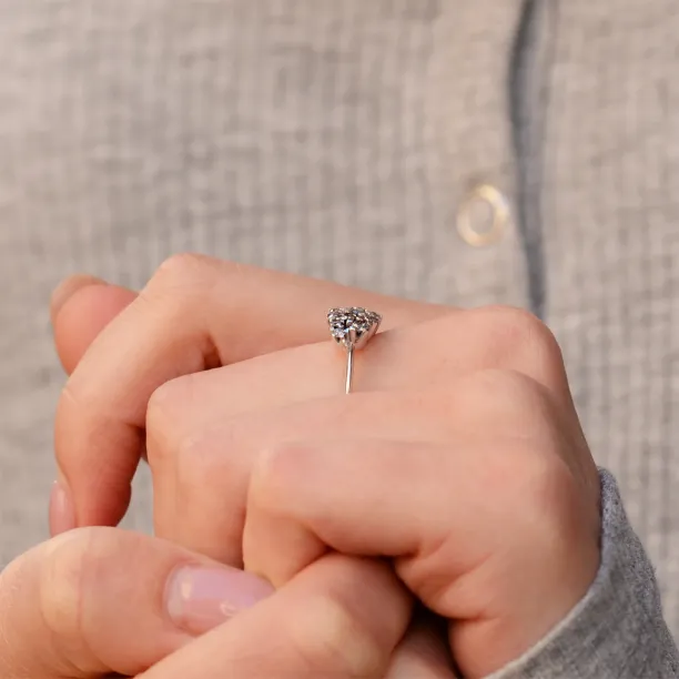 Gold cluster ring with salt and pepper diamonds held between fingers
