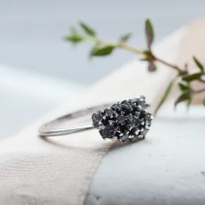 Close-up angled view of the gold cluster ring with salt and pepper diamonds