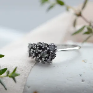 Angled close-up of the SEVERINOS gold cluster ring with salt and pepper diamonds