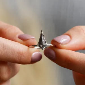 Zásnubní prsten KELLIS s diamantem salt'n'pepper držený mezi prsty