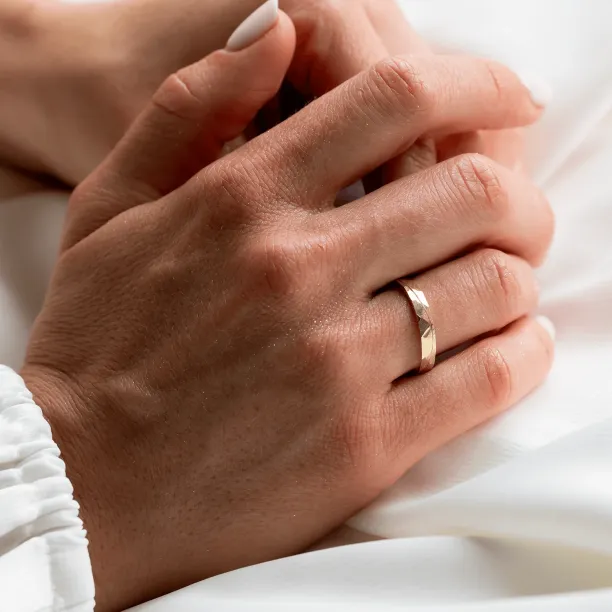 LIDO gold wedding ring worn on a hand
