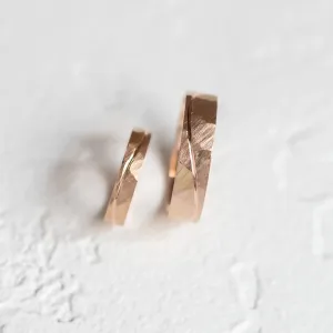 Close-up of gold wedding rings showing the hammered surface and line