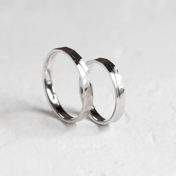 Gold wedding rings standing together with hammered surface and line