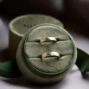 Pair of gold wedding rings displayed in a ring box