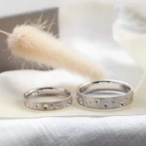 Pair of SELENE space moon wedding bands with varied crater-like perforations