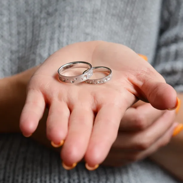 SELENE space moon wedding bands held on an open hand