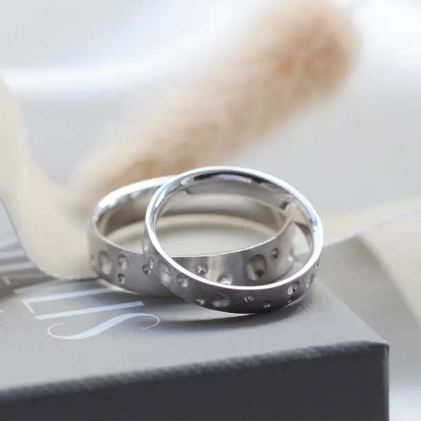 Pair of SELENE wedding bands with crater-like perforations
