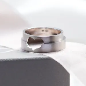 Detail zlatých snubních prstenů LOVE spojených výřezem ve tvaru srdce