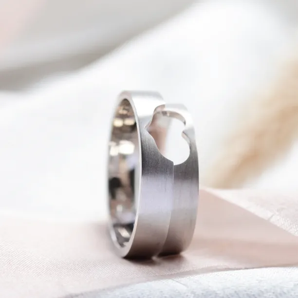 Detailní šikmý pohled na zlaté snubní prsteny LOVE a výřezy ve tvaru srdce