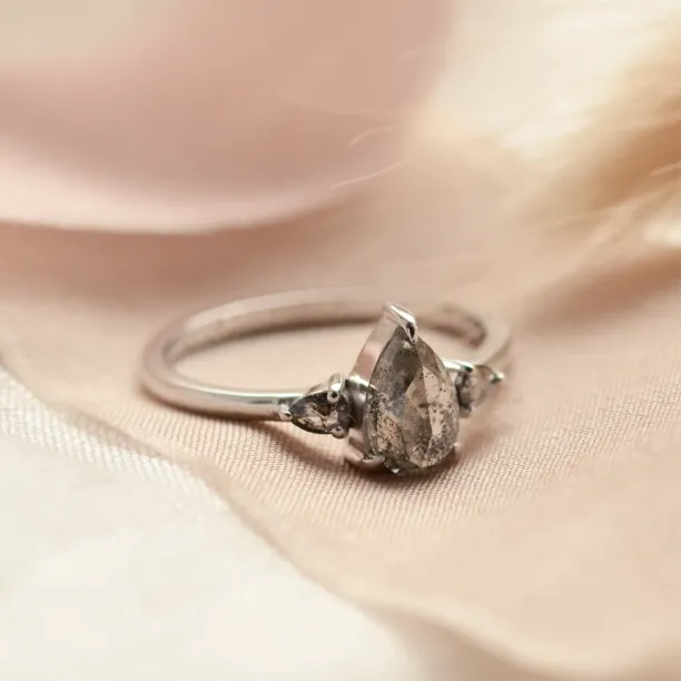 Detailní šikmý pohled na zlatý prsten s pear salt'n'pepper diamanty